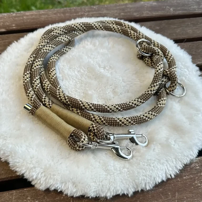 Eine Hundeleine aus einem Tau in Beige auf einem flauschigen, weißen Kissen.